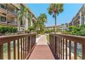 Charming condo exterior showcasing a bridge over a water feature, lush landscaping and palm trees at 3035 Countryside Blvd # 15B, Clearwater, FL 33761