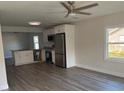 Inviting living room with modern vinyl floors, a ceiling fan, and kitchen views at 8306 N Orleans Ave, Tampa, FL 33604