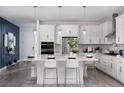 Bright kitchen with white cabinetry, stainless appliances, pendant lighting, and a large center island at 2366 Wise River Lane, Zephyrhills, FL 33539