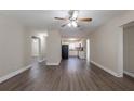 Open living room with modern flooring, neutral walls, and a ceiling fan, leading into the kitchen area at 4621 25Th S Ave, St Petersburg, FL 33711