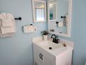 Cozy bathroom features blue walls, vanity with sink and mirror, plus towel rack at 4666 Clarke St, North Port, FL 34286