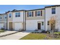 New two-story townhome with a one car garage, brown shutters and a well maintained lawn at 6155 Pina Colada St, Zephyrhills, FL 33542