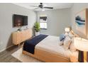 Modern bedroom features a large window, ceiling fan, and stylish furniture at 30406 Arrochar St, Wesley Chapel, FL 33545