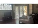 Cozy living room featuring hardwood floors, neutral paint, sliding glass doors and a view of the lanai at 5125 Palm Springs Blvd # 13107, Tampa, FL 33647
