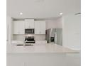 Modern kitchen with white cabinets, quartz countertops, and stainless steel appliances at 14106 Crutchfield Ct, Parrish, FL 34219