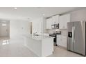 Bright kitchen with white cabinets, stainless steel appliances, and a quartz island at 14106 Crutchfield Ct, Parrish, FL 34219