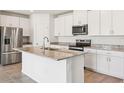 Modern kitchen with stainless steel appliances, granite countertops, and white cabinets and an island sink at 1752 Brekey Way, Zephyrhills, FL 33541