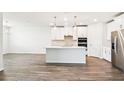 Open-concept kitchen with stainless steel appliances, white cabinets and white backsplash, attached to large living space at 1787 Draughton Dr, Zephyrhills, FL 33541