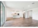 Spacious living room with tiled floors and sliding glass doors leading to the outdoor patio and a kitchen area at 1787 Draughton Dr, Zephyrhills, FL 33541