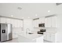 Modern kitchen featuring stainless steel appliances, an island and white cabinetry at 1870 Draughton Dr, Zephyrhills, FL 33541