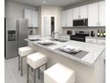 Modern kitchen with white cabinets, stainless steel appliances, granite countertops, and bar seating at 31596 Wild Grape Ln, Brooksville, FL 34602