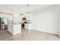 Open concept kitchen with white cabinets, stainless steel appliances, and a center island at 31643 Wild Grape Ln, Brooksville, FL 34602