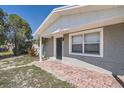 Close up of charming single-story home featuring a covered entrance and brick walkway to the front door at 3206 Peterborough St, Holiday, FL 34690