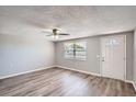 Bright living room featuring wood floors, a ceiling fan, neutral paint and a window at 3206 Peterborough St, Holiday, FL 34690