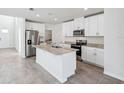 Bright kitchen features an island, stainless steel appliances, and white cabinets at 437 Lazy Shore Dr, Nokomis, FL 34275