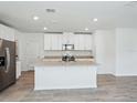 Open kitchen featuring an island, stainless steel appliances, granite countertops, and white cabinets at 437 Lazy Shore Dr, Nokomis, FL 34275