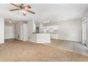 Open living space featuring a ceiling fan, neutral walls, and a view into the kitchen at 2174 Brubeck Rd, North Port, FL 34287