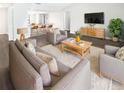 Bright and open living room with modern furniture, grey couches and a view into the kitchen at 22162 Weeks Blvd, Land O Lakes, FL 34639