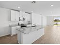 Modern kitchen with white cabinets, granite countertops, and stainless steel appliances at 137 Whiteland Bnd, Nokomis, FL 34275