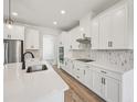 Bright, modern kitchen with white cabinets, stainless steel appliances, and tile backsplash at 14035 Kelly Park Ct, Parrish, FL 34219