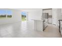 Open-concept kitchen and living area with island, bright light, and backyard views at 7736 Gilchrist Springs Dr, Parrish, FL 34219