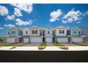Charming row of newly constructed townhomes featuring colorful exteriors and attached garages at 42854 Park View Dr Way, Punta Gorda, FL 33982