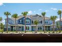 New townhomes boast vibrant exteriors and lush landscaping with palm trees and inviting entryways under a sunny, blue sky at 17378 Alderwood Ln, Punta Gorda, FL 33982