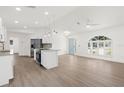 Open-concept living area with new wood-look floors, bright paint, and updated lighting fixtures at 4284 Persian Ln, North Port, FL 34287