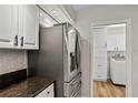 Modern kitchen featuring stainless steel refrigerator and updated cabinets, conveniently located next to the laundry area at 6731 Northlake Dr, Zephyrhills, FL 33542