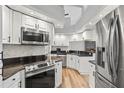 Well-lit kitchen boasts stainless steel appliances, white cabinets, and a stylish backsplash for a modern touch at 6731 Northlake Dr, Zephyrhills, FL 33542