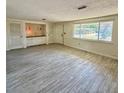 Bright living room with large window, tiled floor, and built in storage at 5428 Nutmeg Ave, Sarasota, FL 34231