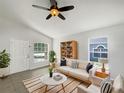 Bright living room features natural light, ceiling fan, and stylish décor, perfect for relaxation and entertaining at 923 Brenton Leaf Dr, Ruskin, FL 33570