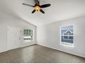 Bright living room with tile floors, a ceiling fan, a front door and large windows at 923 Brenton Leaf Dr, Ruskin, FL 33570