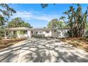 Charming single-story home featuring a spacious driveway and an open carport with landscaping at 4925 Alcazar S Way, St Petersburg, FL 33712