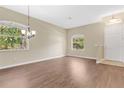 Spacious living room featuring wood flooring, natural light, and a modern chandelier at 12219 Hunters Lake Dr, New Port Richey, FL 34654