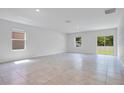 Bright living room with tile flooring, large windows, and sliding door access to the backyard at 3504 Kearsney Abbey Cir, Dover, FL 33527