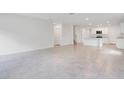 Open-concept living space with tile flooring and abundant natural light flows into the kitchen at 3504 Kearsney Abbey Cir, Dover, FL 33527