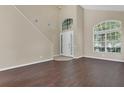 Bright entryway featuring soaring ceilings, dark wood-look floors, and an abundance of natural light at 4432 Huddlestone Dr, Wesley Chapel, FL 33545