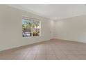 Bright living room with neutral tile flooring and a large window offering a pleasant outdoor view at 4722 67Th N Ave, Pinellas Park, FL 33781