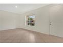 Inviting living area featuring neutral tile, crown molding, and a large window for plenty of natural light at 4722 67Th N Ave, Pinellas Park, FL 33781