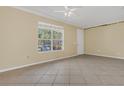 Bright living room with ceramic tile flooring, large window, and neutral paint throughout the space at 4722 67Th N Ave, Pinellas Park, FL 33781