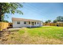 Expansive backyard featuring a manicured lawn, new privacy fence, and covered patio perfect for entertaining at 7824 Starkey Rd, Seminole, FL 33777