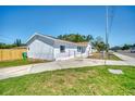 A charming single-story home featuring a well-manicured lawn, freshly painted exterior, and a chain-link fence at 7824 Starkey Rd, Seminole, FL 33777