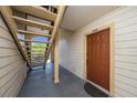 Condominium entrance featuring a brown front door, stairs and neutral exterior with unit number 2107 at 11901 4Th N St # 2107, St Petersburg, FL 33716