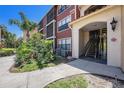 Inviting exterior view showcasing a red condominium building with lush landscaping and architectural details at 11901 4Th N St # 2107, St Petersburg, FL 33716