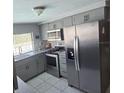 Well-lit kitchen with stainless steel appliances, gray cabinets, and a view of the outdoor pool at 3309 Rock Valley Dr, Holiday, FL 34691