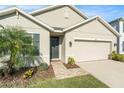 Close up view of the front door and the beautiful stone-paved walkway, landscaping and attached two-car garage at 2587 Garden Plum Pl, Odessa, FL 33556