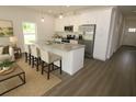 Open-concept kitchen featuring white cabinetry, granite countertops, stainless steel appliances, and a center island at 8990 Glenarm Way, Weeki Wachee, FL 34613