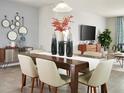 Elegant dining room with a wooden table, six chairs, modern decor, and tiled floors at 160 Lazy Shore Dr, Nokomis, FL 34275