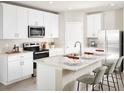 Stylish kitchen with white cabinets, stainless steel appliances, and seating at the island at 193 Lazy Shore Dr, Nokomis, FL 34275
